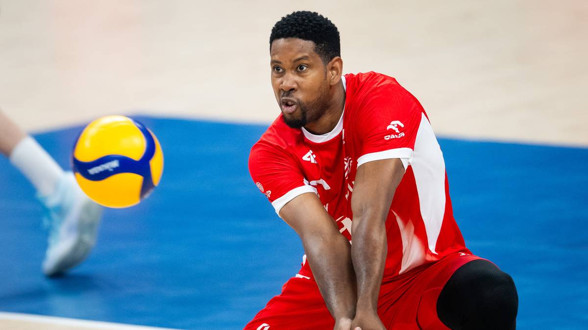 Siatkarz w czerwonej koszulce odbija piłkę podczas meczu.