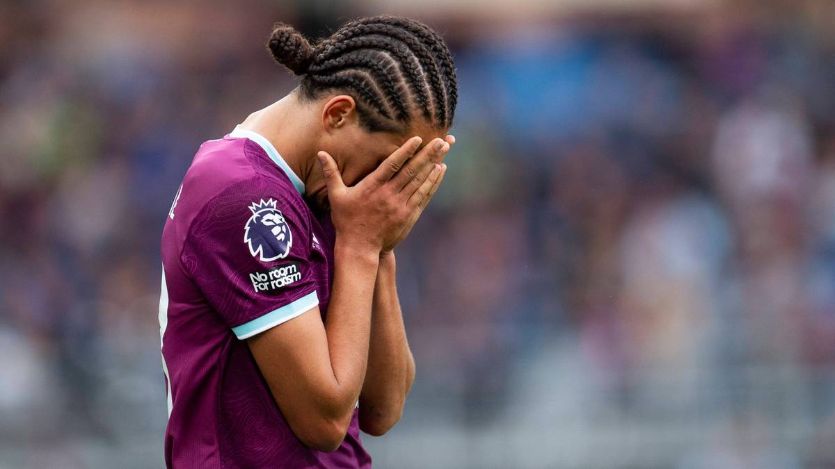 Piłkarz w koszulce z herbem klubu Premier League zasłania twarz dłońmi.