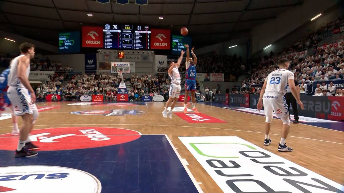 Koszykarze rywalizujący na boisku podczas meczu, jeden z zawodników oddaje rzut do kosza.