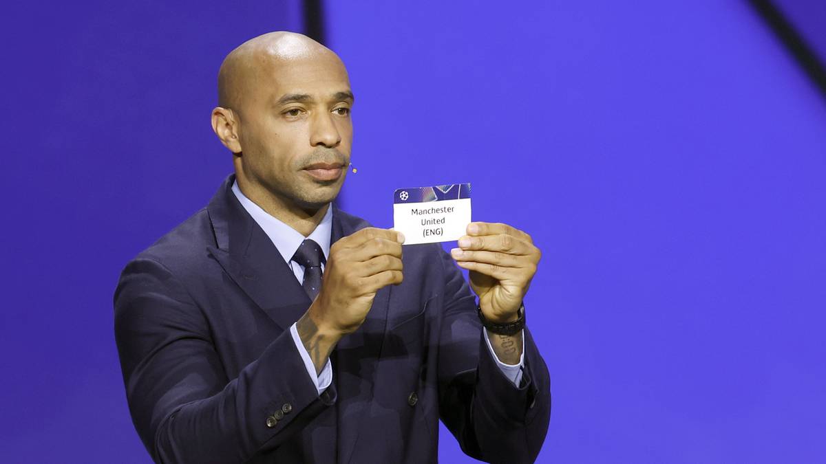 Thierry Henry w garniturze trzyma kartkę z napisem "Monaco - Argent".