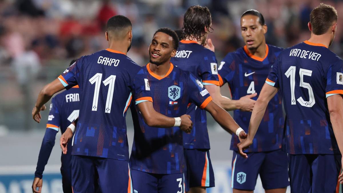 Holenderscy piłkarze w niebieskich strojach świętują bramkę lub zwycięstwo.
