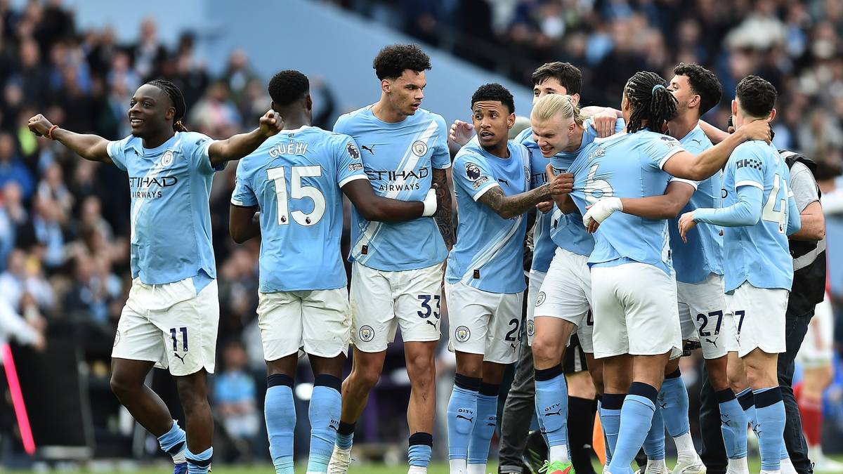 Drużyna piłkarska Manchesteru City świętująca na boisku po strzelonym golu.