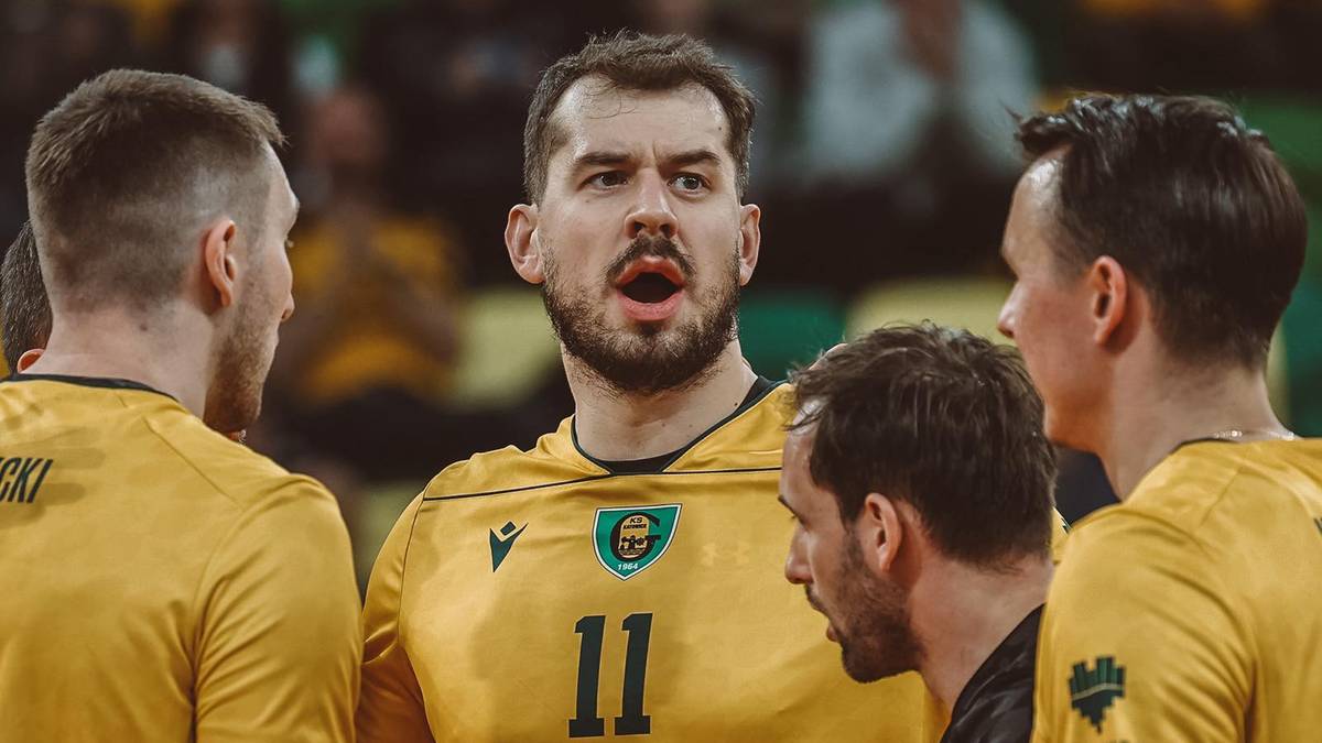 Siatkarze w ż&oacute;łtych strojach z numerem 11 rozmawiają między sobą na boisku.