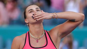 Aryna Sabalenka świętująca zwycięstwo, z ręką na ustach.