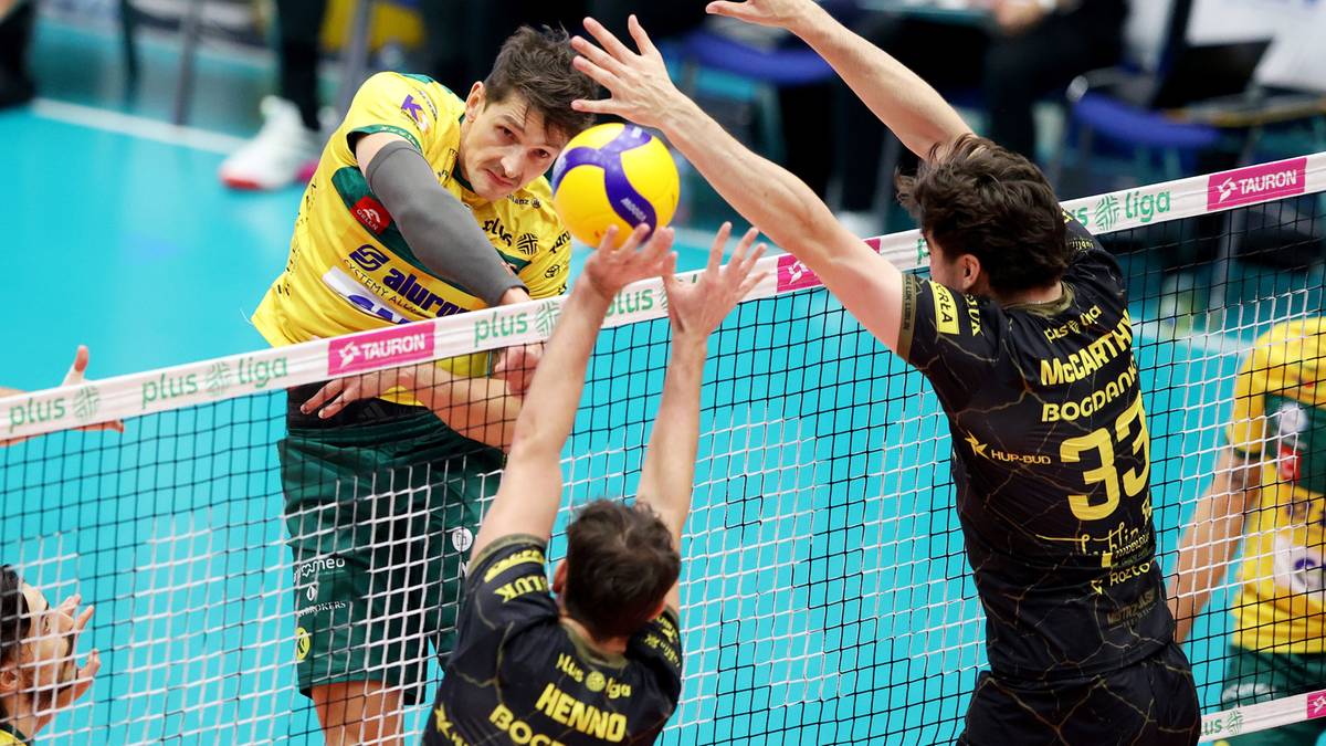 Siatkarze Aluron CMC Warta Zawiercie i Bogdanka LUK Lublin w akcji. Jeden z zawodnik&oacute;w w ż&oacute;łtej koszulce pr&oacute;buje zablokować atak przeciwnika.