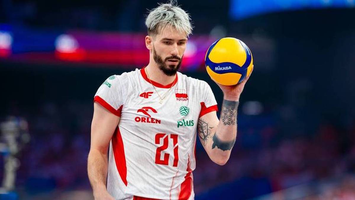 Siatkarz Tomasz Fornal w stroju reprezentacyjnym z piłką do siatk&oacute;wki.