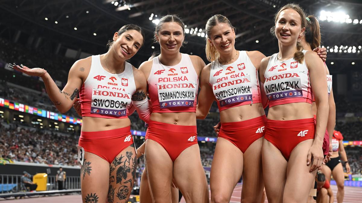 Cztery lekkoatletki w czerwono-białych strojach reprezentacji Polski, trzymające się za ręce i uśmiechnięte, pozują do zdjęcia na stadionie lekkoatletycznym.