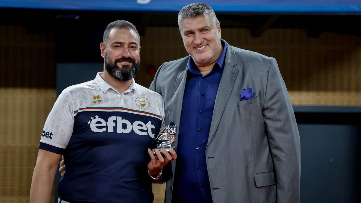 Dw&oacute;ch mężczyzn pozuje do zdjęcia, jeden z nich trzyma statuetkę.