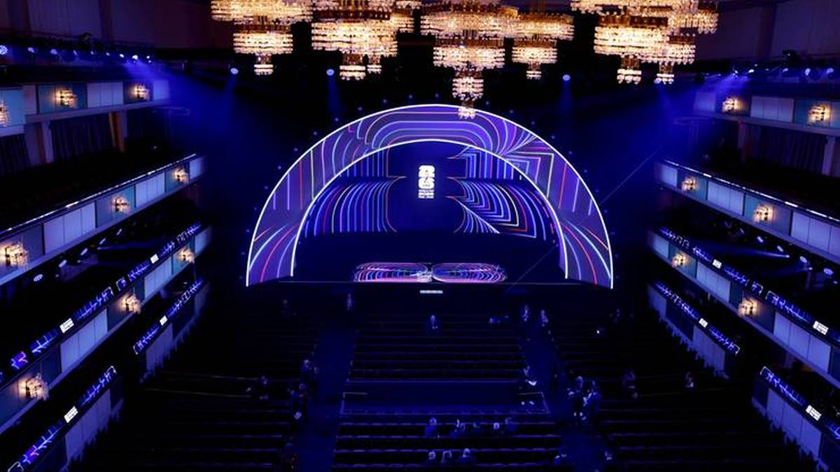 Duża scena z łukowatym ekranem w tle, oświetlona niebieskim światłem. Wok&oacute;ł sceny znajdują się rzędy siedzeń dla widowni, a nad nią wiszą liczne żyrandole.