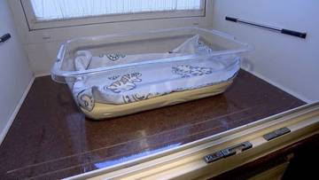 Przezroczysty pojemnik na niemowlę z prześcieradłem w środku, umieszczony w oknie życia.