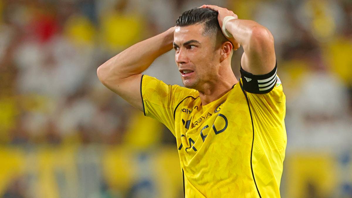Cristiano Ronaldo w ż&oacute;łtej koszulce z rękami na głowie, piłkarz Al-Nassr.