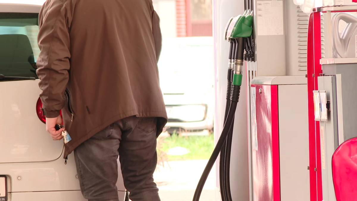 Osoba tankująca samoch&oacute;d na stacji paliw.