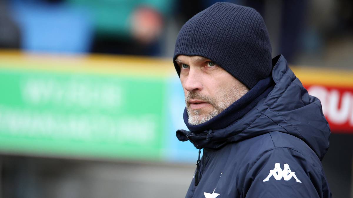 Mężczyzna w czapce i kurtce sportowej z logo.