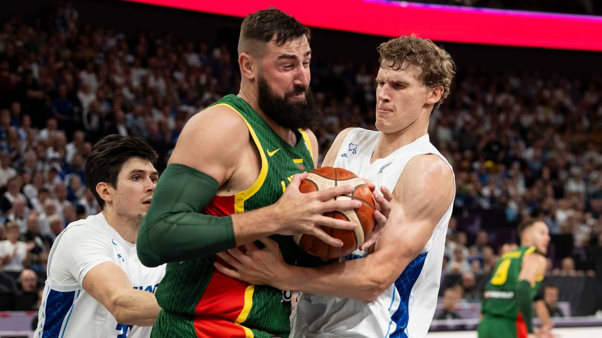 Dw&oacute;ch koszykarzy w trakcie meczu walczy o piłkę. Jeden z nich w zielonej koszulce z numerem 8 pr&oacute;buje odebrać piłkę przeciwnikowi w białej koszulce.