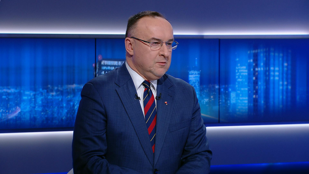 Michał Kobosko w garniturze siedzi w studiu telewizyjnym.