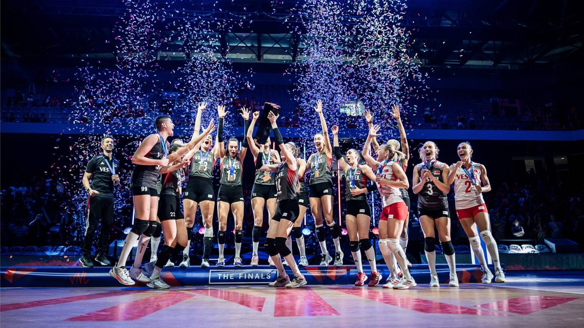 Druzyna siatkarek świętuje zwycięstwo na podium, obsypana konfetti.