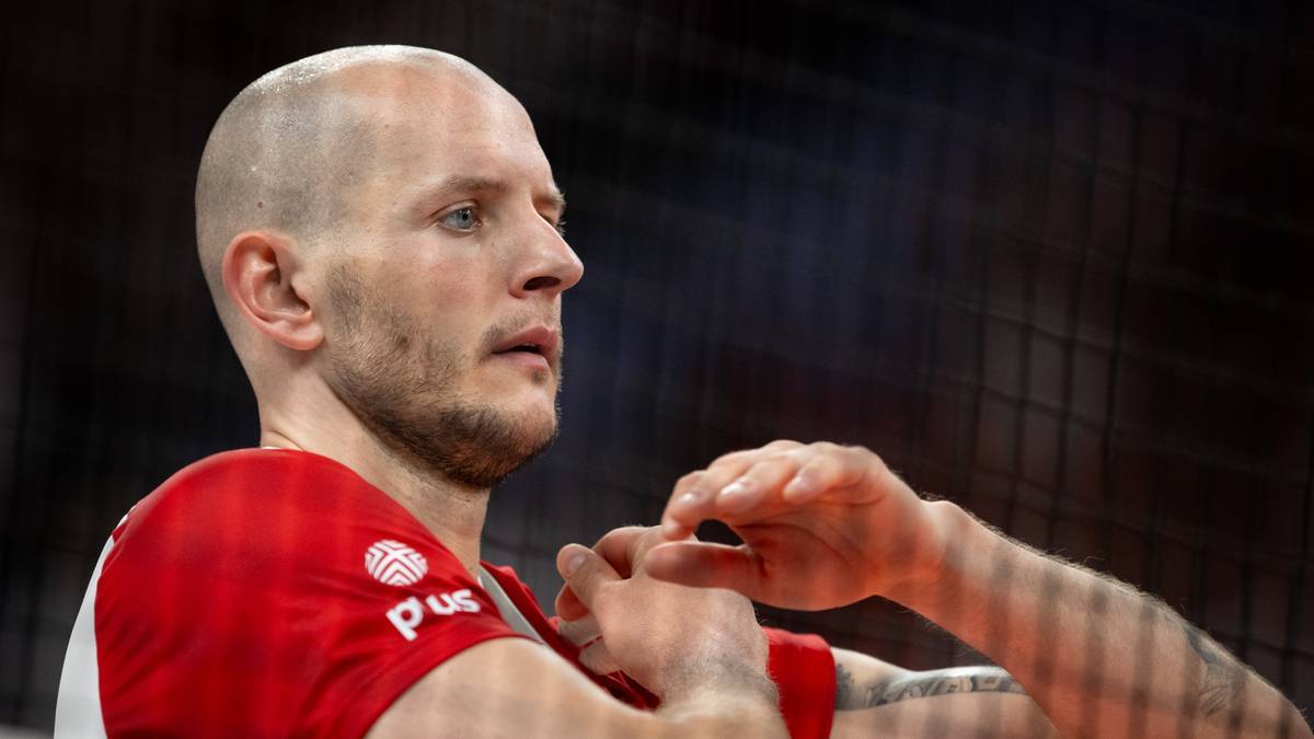 Portret siatkarza Bartosza Kurka w czerwonej koszulce z białym logo.