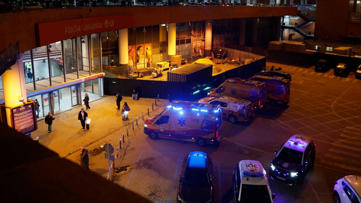 Nocny widok na dworzec kolejowy z radiowozami i pojazdami ratunkowymi.