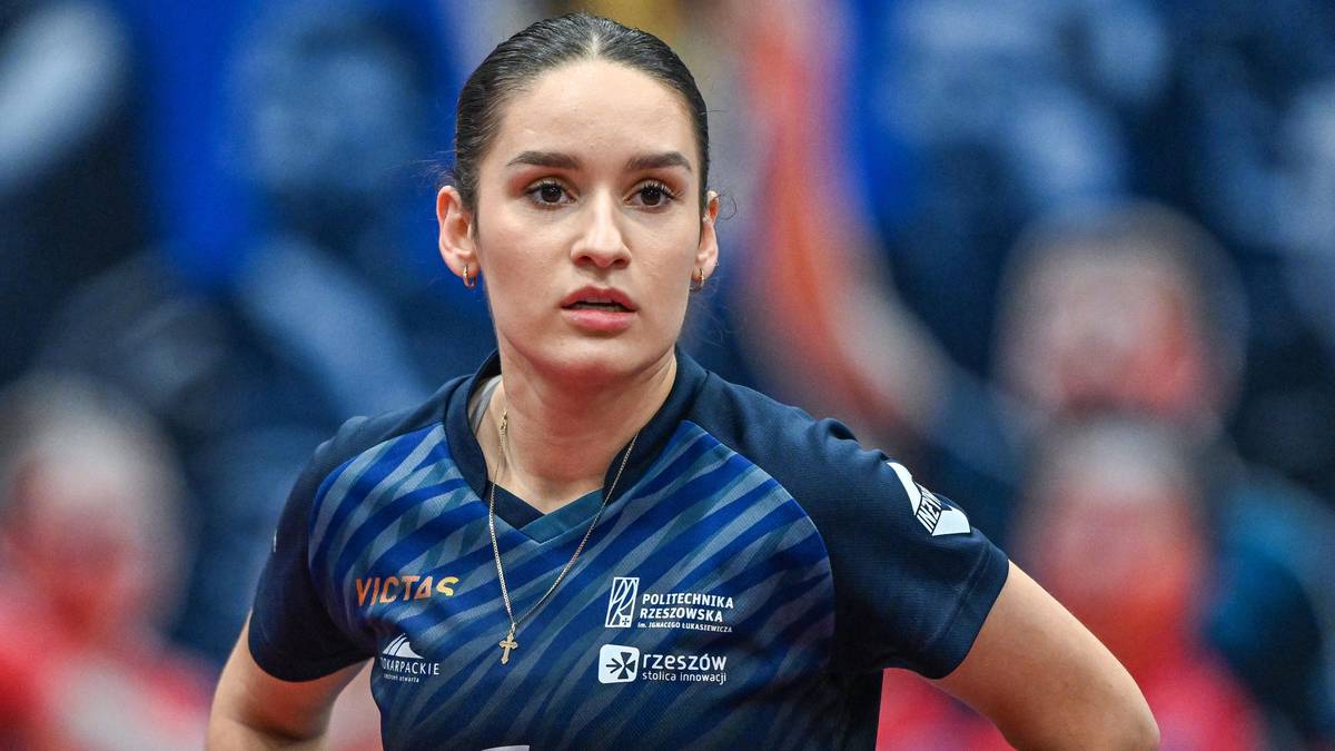Portret tenisistki stołowej Zuzanny Wielgos, skupionej podczas meczu, w niebiesko-czarnej koszulce sportowej z logo PGE.