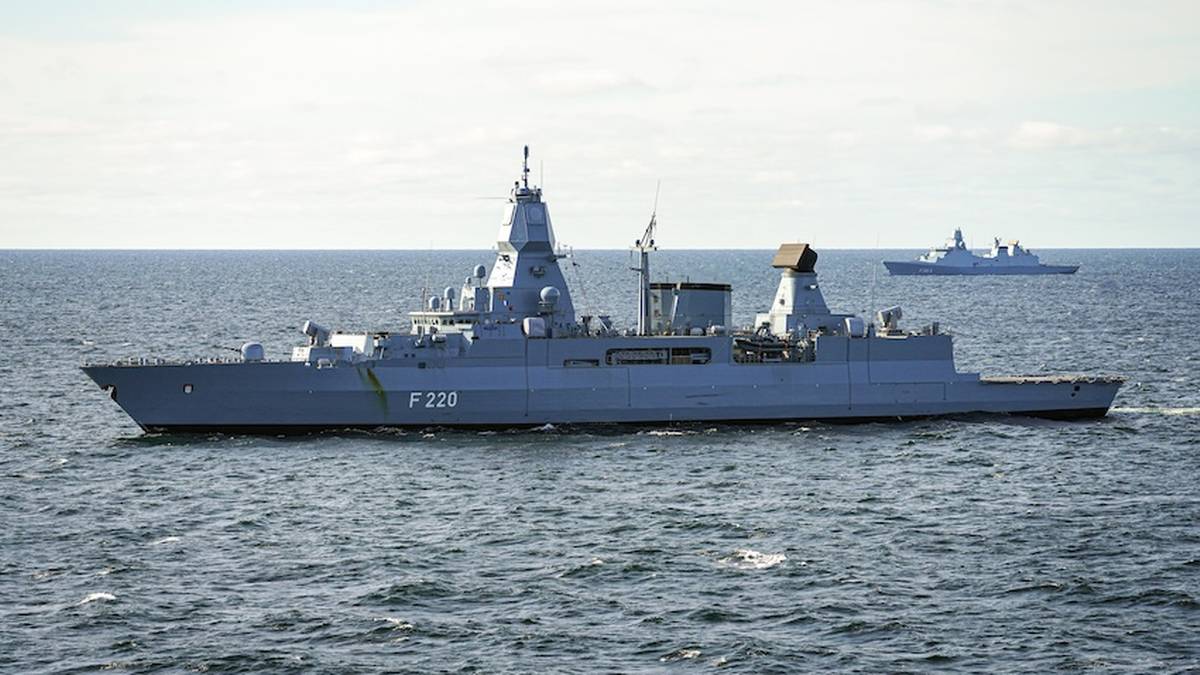 Niemiecki okręt wojenny F220 "Sachsen" na morzu, z innym okrętem widocznym w oddali.