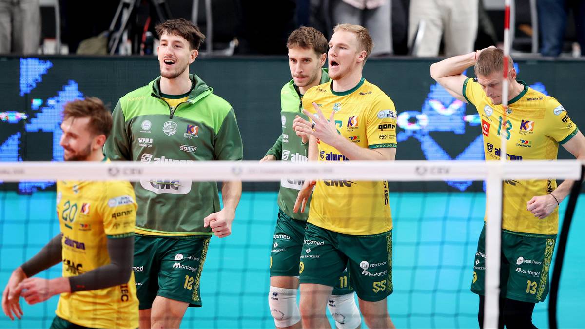 Siatkarze w żółtych i zielonych strojach rywalizują przy siatce.