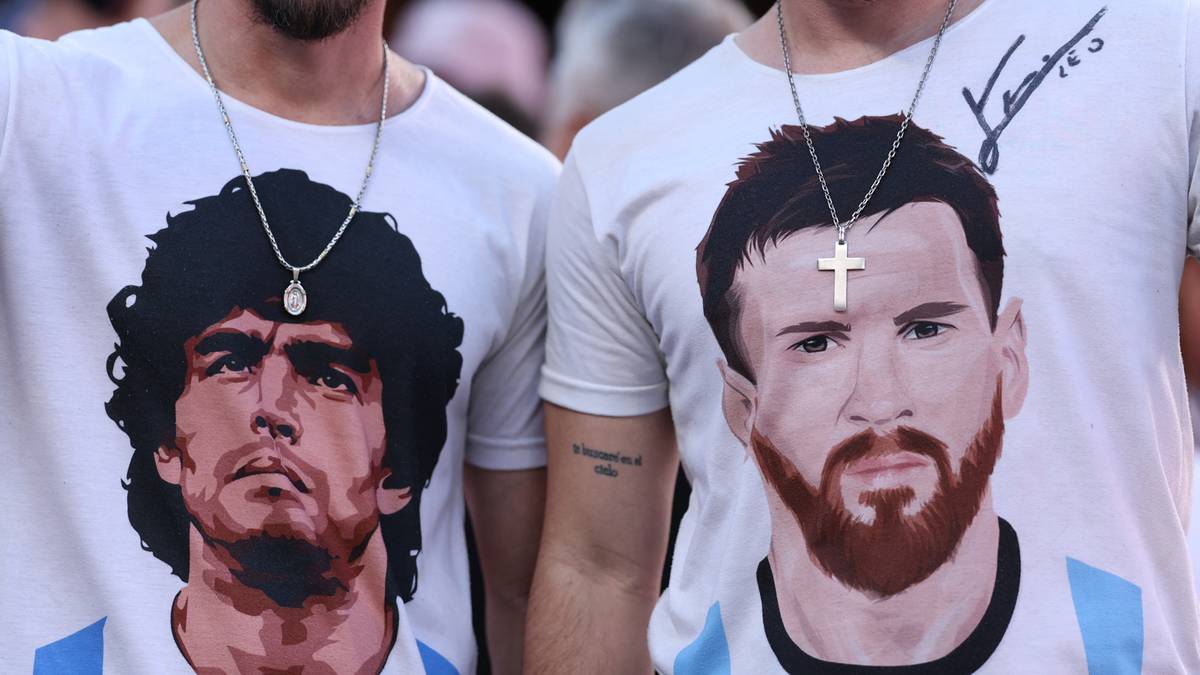 Dw&oacute;ch mężczyzn noszących białe koszulki z wizerunkami Diego Maradony i Lionela Messiego.
