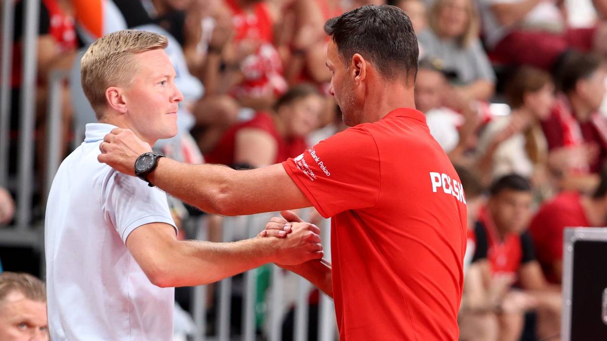 Dwóch mężczyzn w strojach sportowych uściski dłoni na tle publiczności.