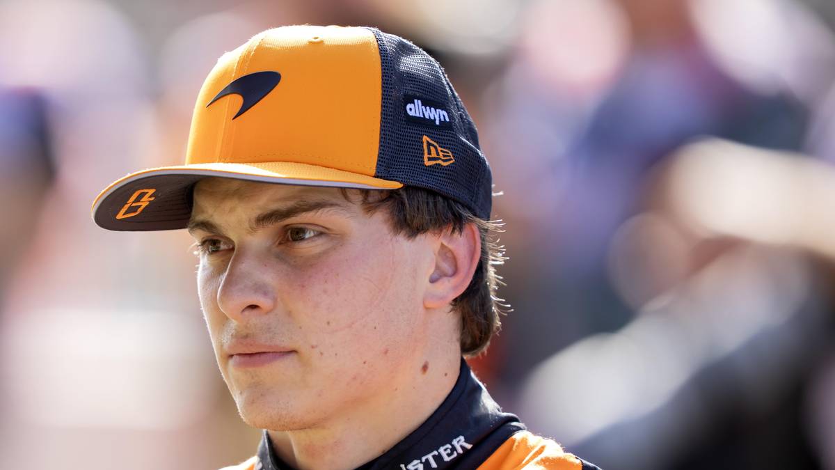 Portret młodego mężczyzny w czapce z daszkiem zespołu McLaren, z logo zespołu po lewej stronie.