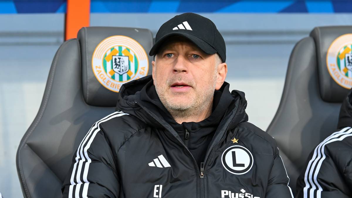 Portret mężczyzny w czapce z daszkiem i kurtce z logo Legii Warszawa.