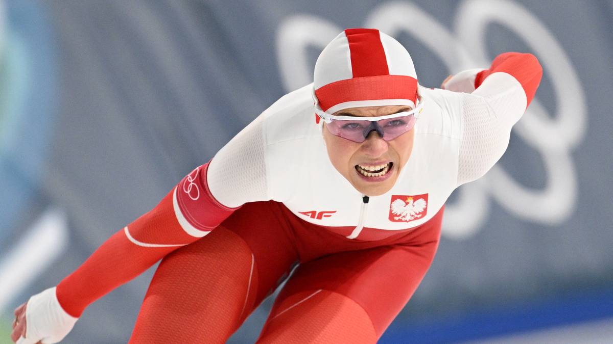 Łyżwiarka w biało-czerwonym stroju z orłem na piersi w trakcie wyścigu.