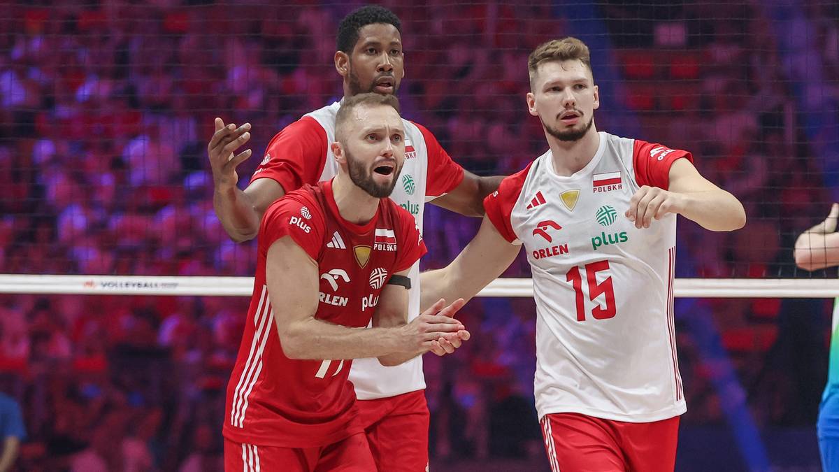 Siatkarze reprezentacji Polski w czerwonych i białych strojach podczas meczu, jeden z nich pokazuje gest ręką.