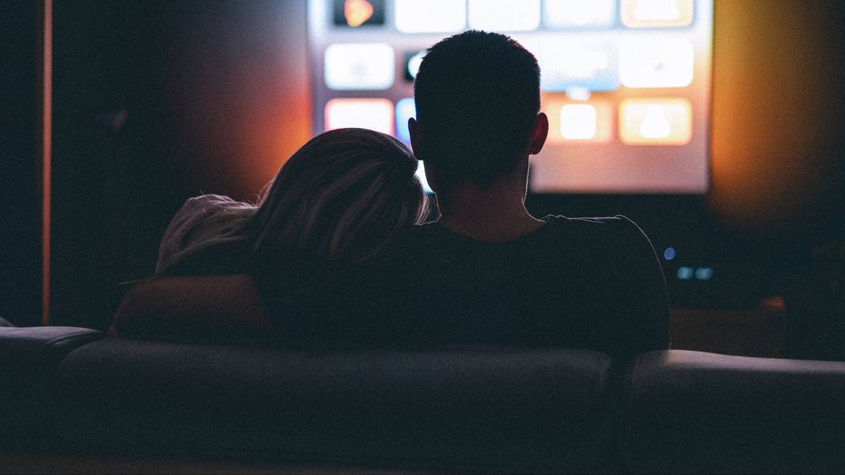 Para oglądająca telewizję w ciemnym pokoju