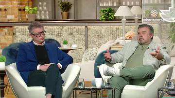 Dw&oacute;ch mężczyzn siedzi w eleganckich fotelach i rozmawia. Jeden z nich jest w niebieskiej marynarce, drugi w jasnej. W tle znajdują się elementy wystroju wnętrza.