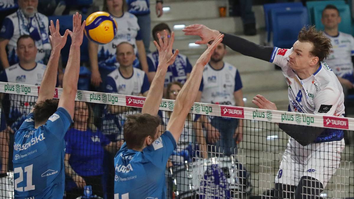 Siatkarze podczas meczu siatk&oacute;wki, jeden z nich pr&oacute;buje zablokować atak przeciwnika.