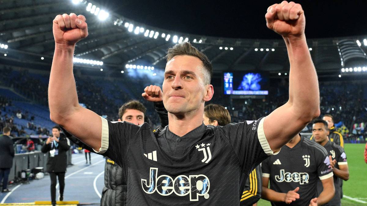 Arkadiusz Milik, piłkarz Juventusu, świętuje zwycięstwo z podniesionymi pięściami na stadionie.