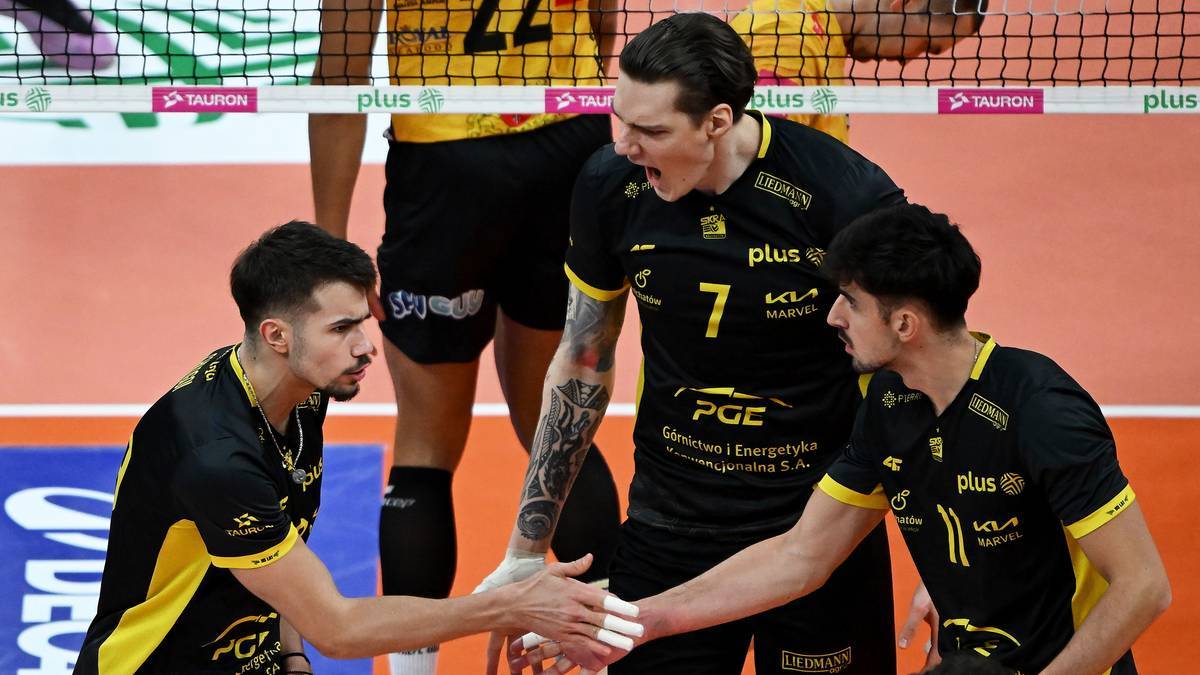 Trzech siatkarzy w strojach drużynowych podczas meczu.