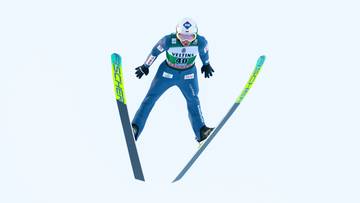 Skoczek narciarski w powietrzu podczas skoku na nartach.