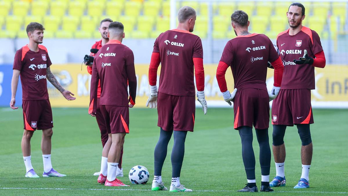 Grupa piłkarzy w bordowych strojach reprezentacji Polski podczas treningu na boisku piłkarskim.