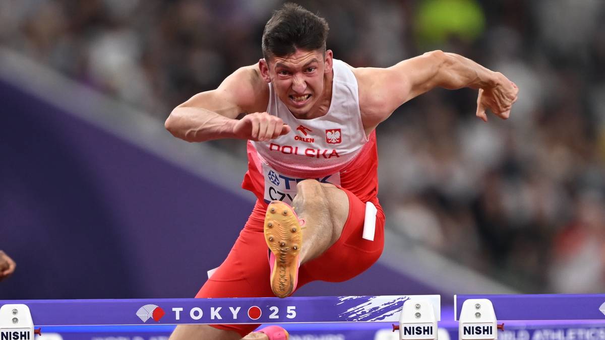 Sportowiec w stroju z orłem i napisem "POLSKA" pokonuje płotek w biegu na stadionie.