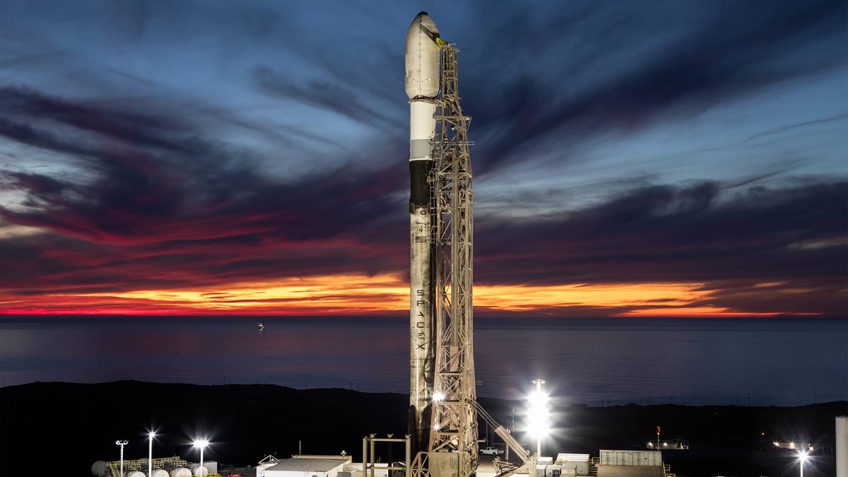 Rakieta Falcon 9 na platformie startowej na tle zachodzącego słońca.