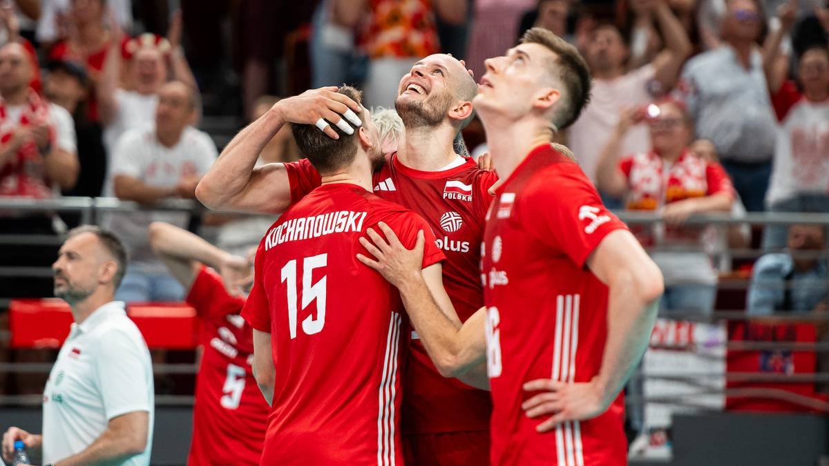 Trzech siatkarzy w czerwonych strojach reprezentacji Polski cieszy się po wygranej, jeden z nich podnosi ręce do g&oacute;ry w geście radości.