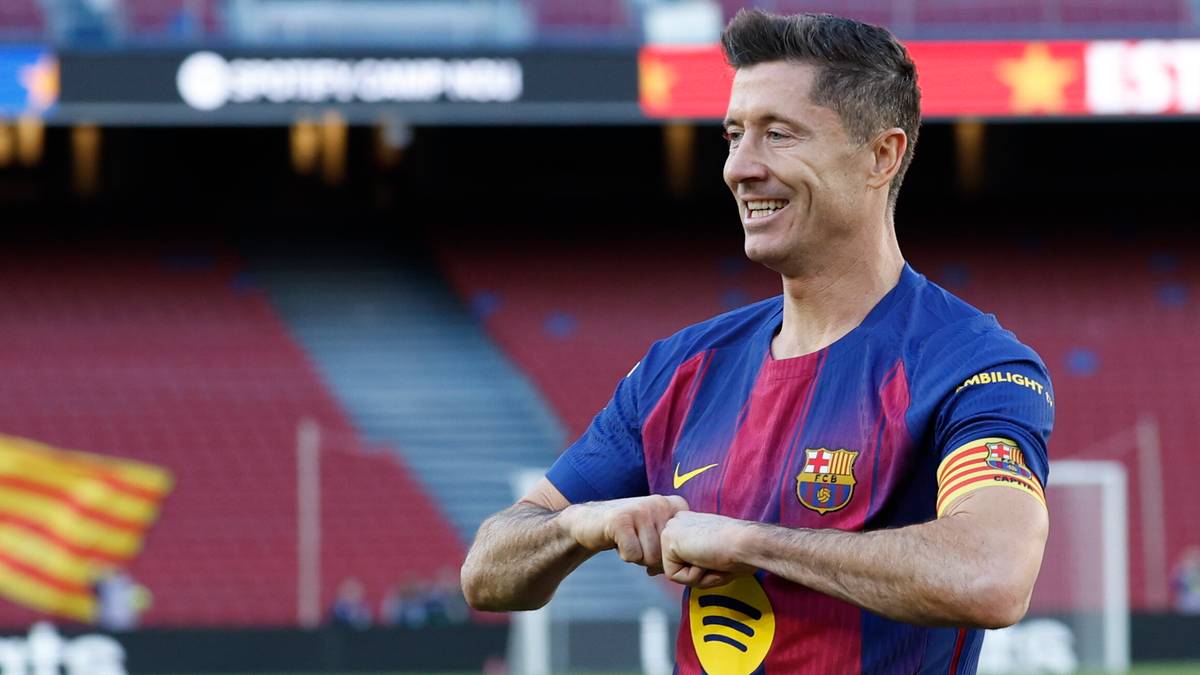 Robert Lewandowski w stroju FC Barcelony, cieszący się na boisku piłkarskim.