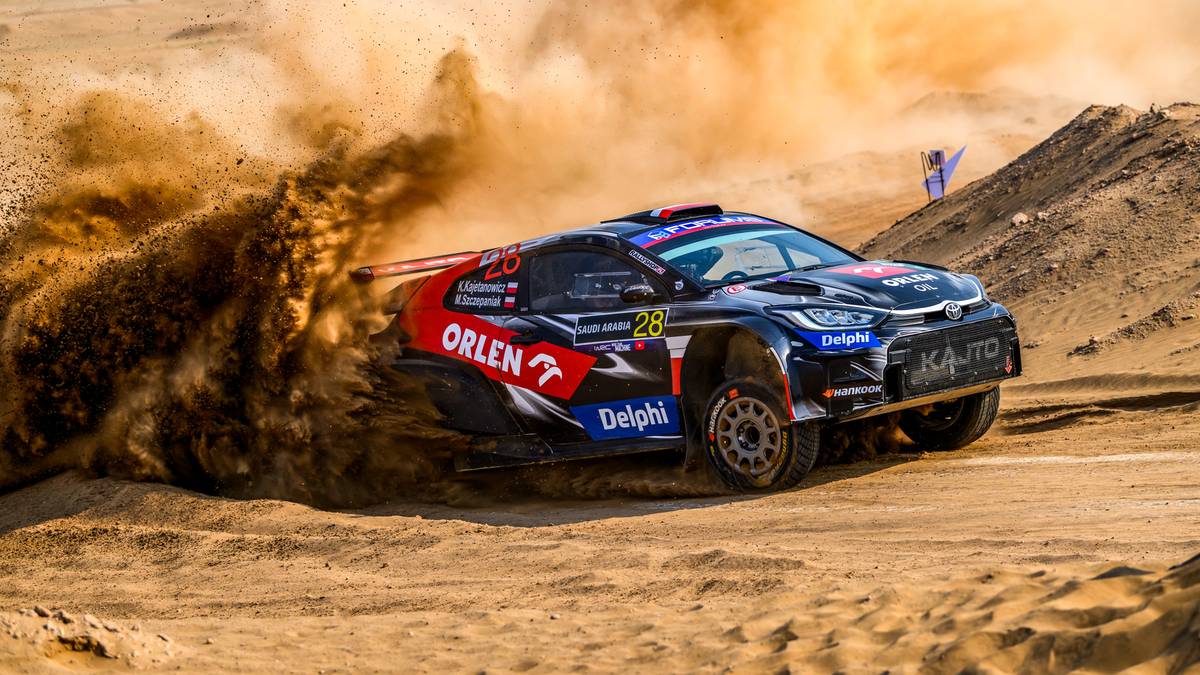 Rajdowy samochód ORLEN Rally Team z numerem 25 pokonuje pustynną trasę, wzbijając piasek.