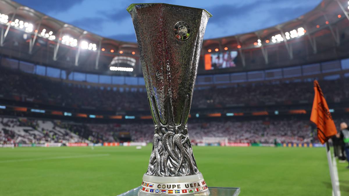 Puchar Ligi Europy stojący na zielonej murawie stadionu piłkarskiego.