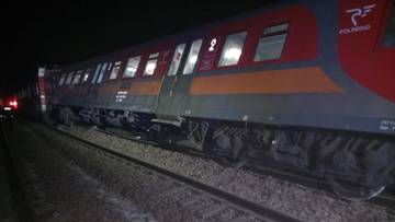 Część wykolejonego pociągu Polregio na torach nocą.