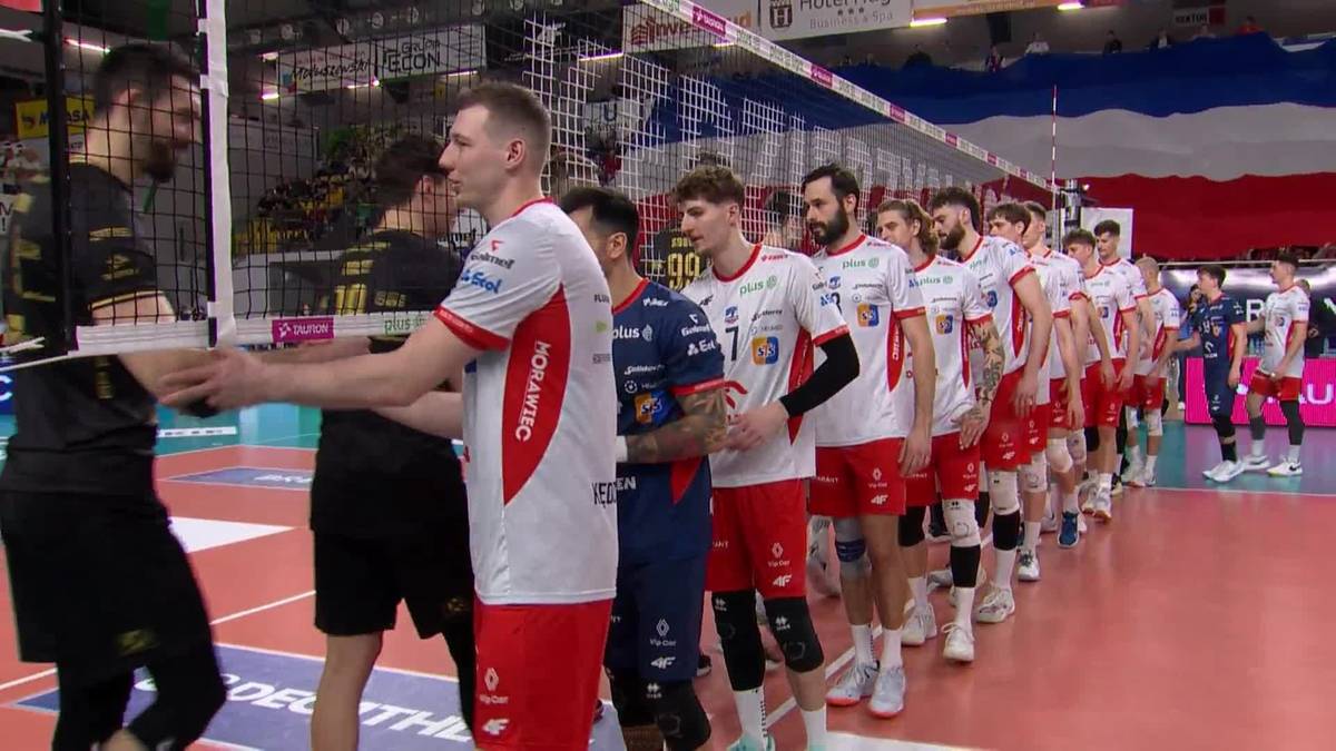 Dwóch siatkarzy podaje sobie ręce po meczu na tle swoich drużyn.