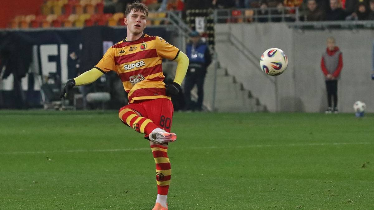 Młody piłkarz w stroju Jagiellonii Białystok podczas meczu.