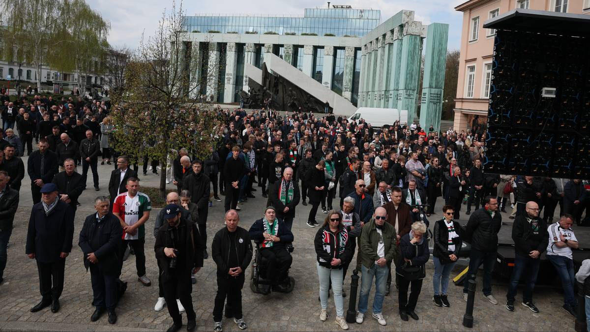 Tłum ludzi zgromadzonych na zewnątrz, przed budynkiem.