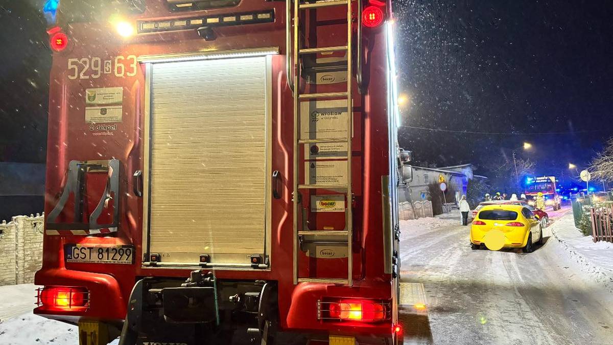 Tylna część wozu strażackiego OSP Pinczyn na zaśnieżonej drodze nocą.