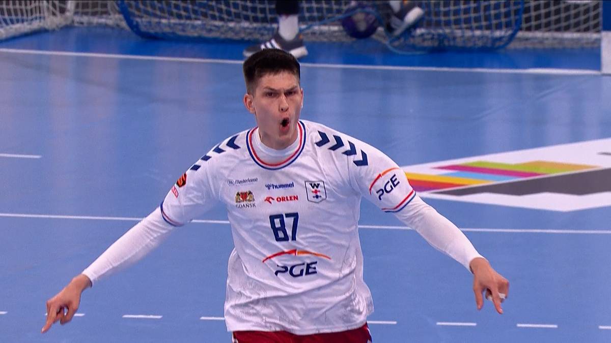 Piłkarz ręczny w białej koszulce z numerem 87 krzyczy z radości.